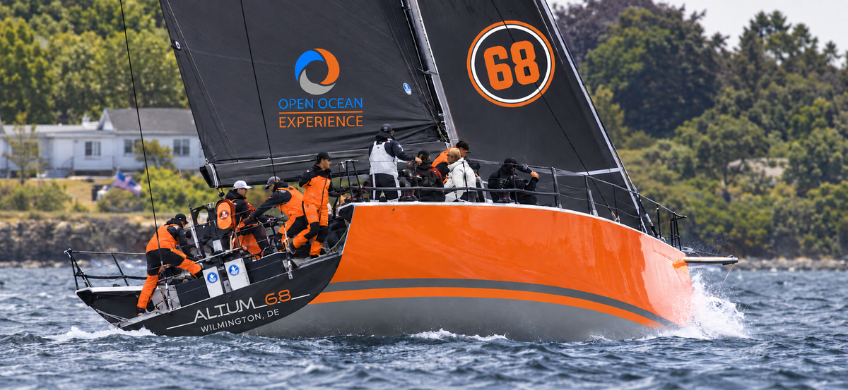 Client-supplied Altum 68 livery visualisation: the orange yacht under sail, viewed from astern.